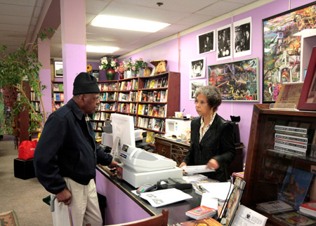 Co-owner Karen Johnson talks with a customer at the counter of Marcus Books.