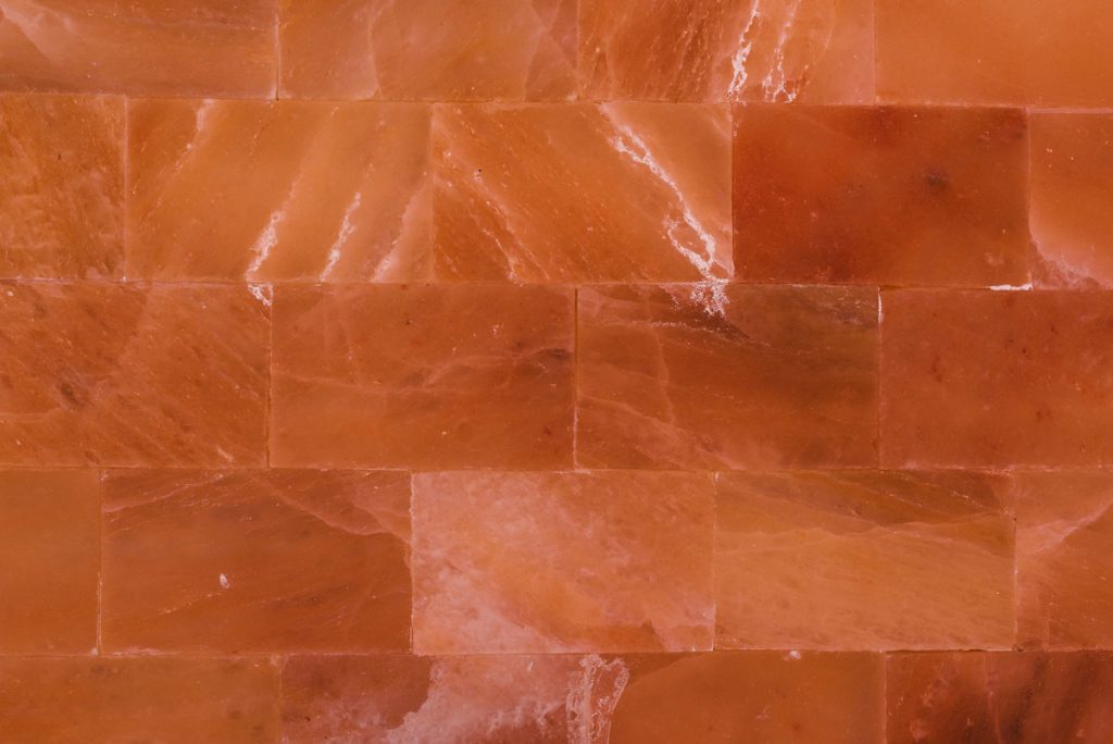 The Himalayan Salt Room is lined in rosy pink salt slabs.