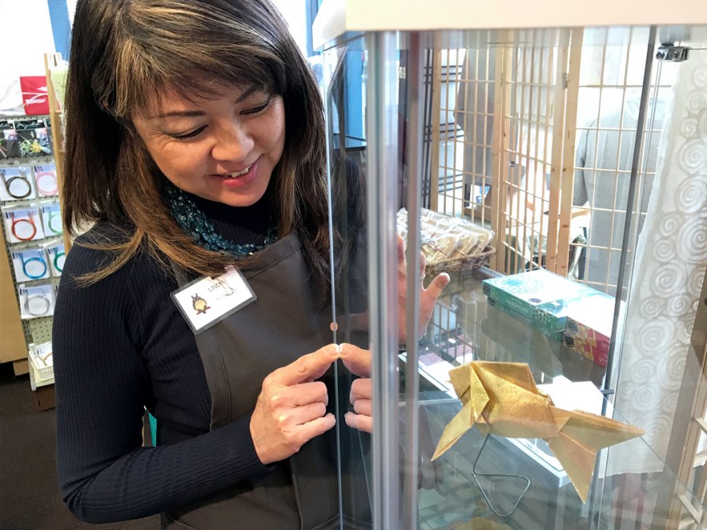 Paper Tree's Linda Mihara with a goldfish made of gold paper.